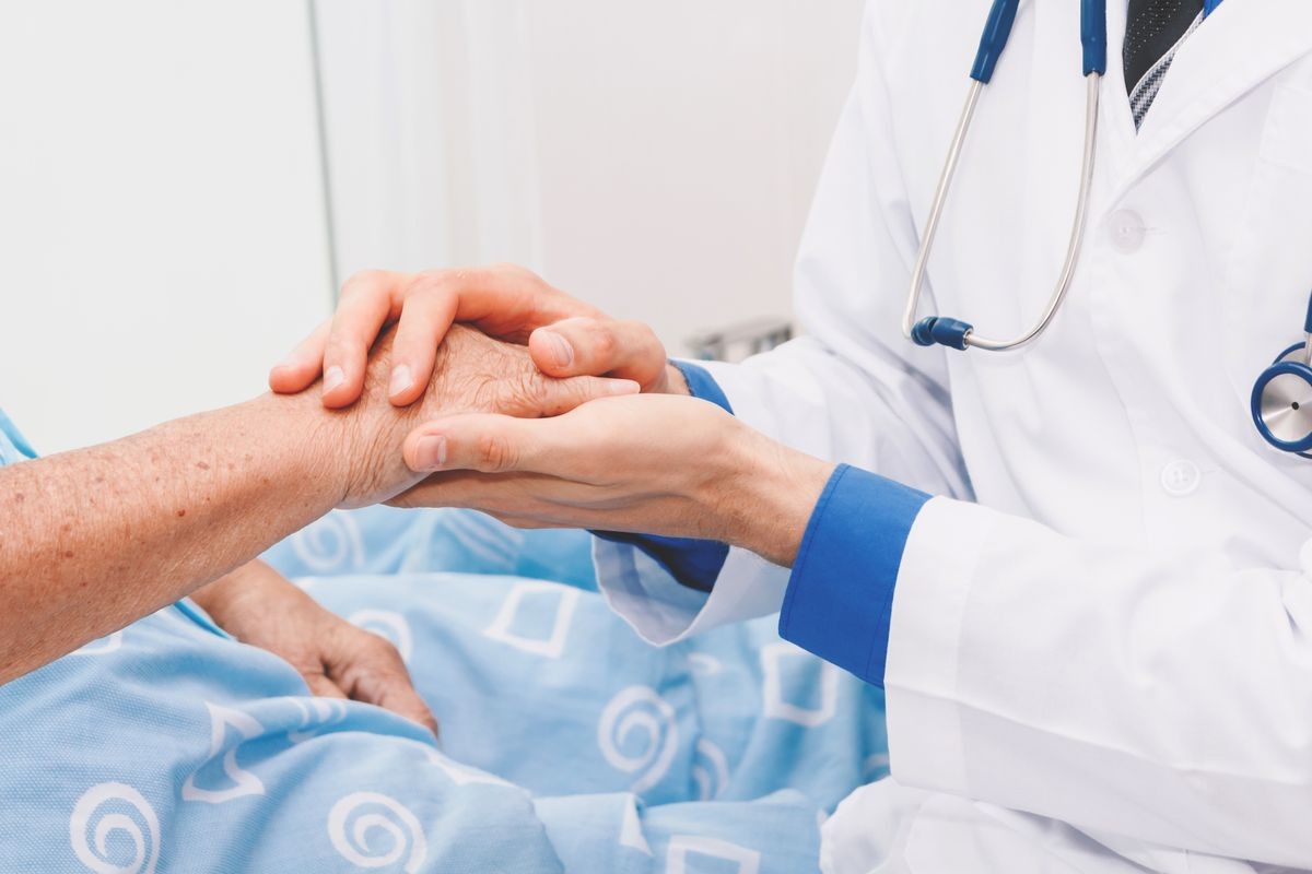 Doctor holding elderly person hand with care in hospital.healthcare and medicine